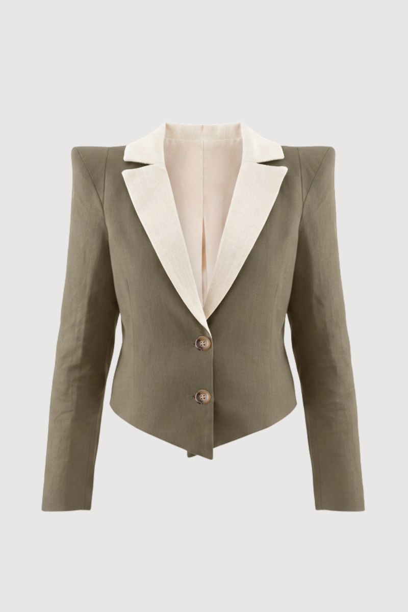 Chaqueta con hombreras en color verde caqui y solapa a contraste en color crema. Está forrada y se cierra con dos botones en el delantero.