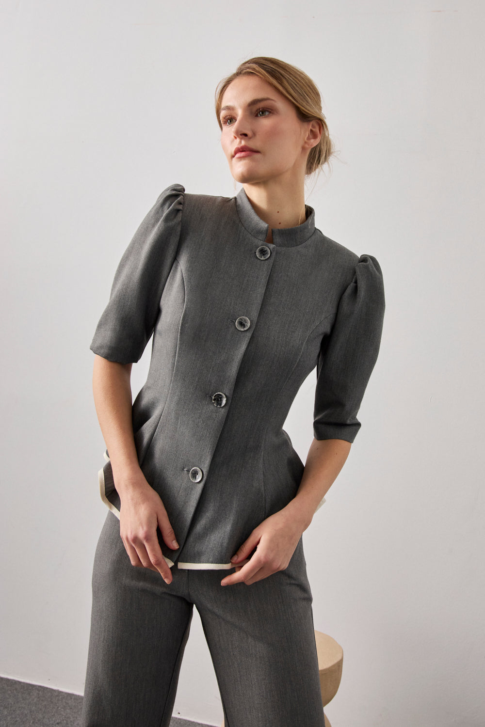 Pantalón de pinzas y pernera recta en color gris.Cuenta con bolsillos delanteros y cierre con botón.