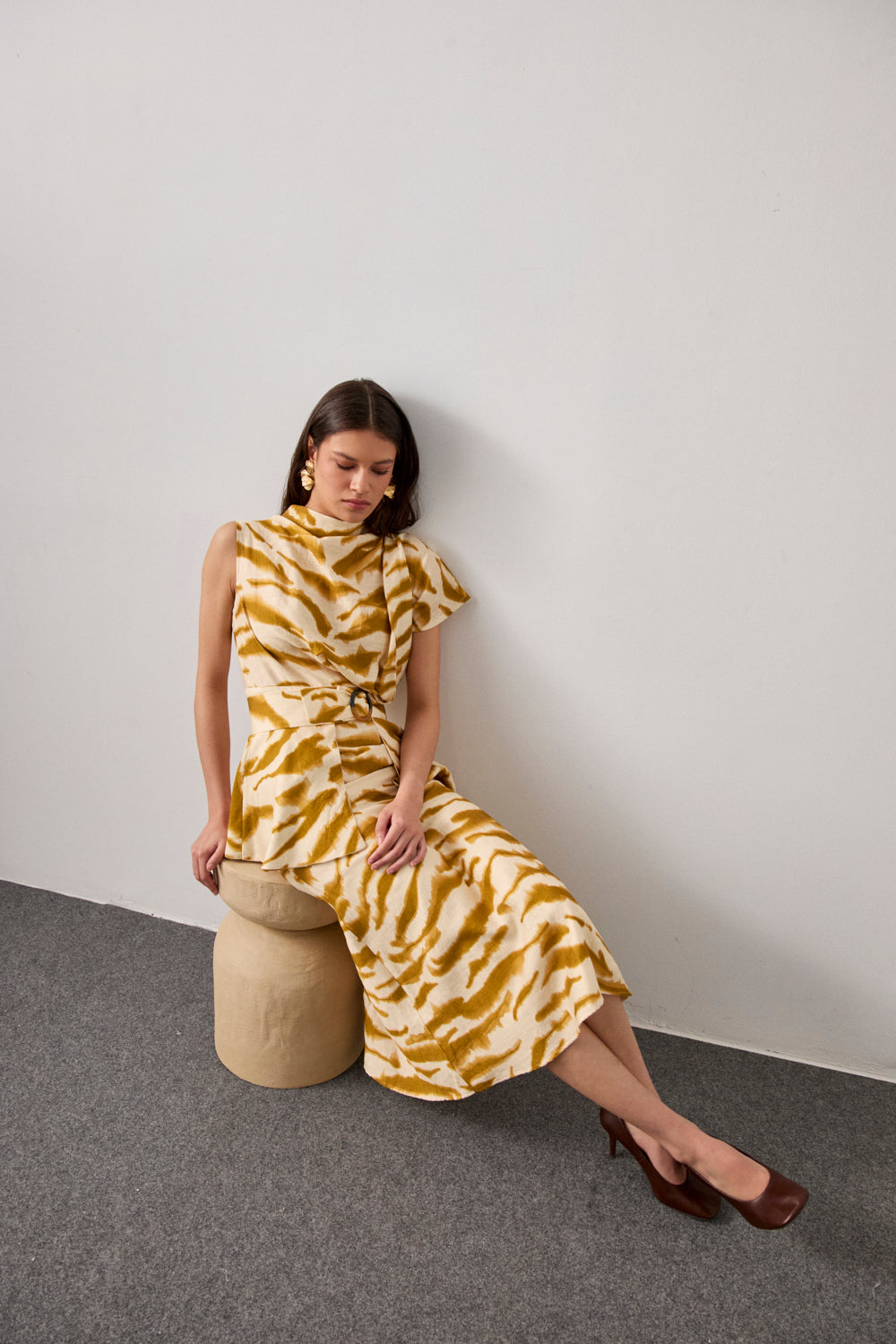 Vestido midi en color crema y manchas mostaza con mangas asimétricas.Este vestido tiene escote a la caja, corte en la cintura y cinturón confeccionado en el mismo tejido con hebilla tipo carey.