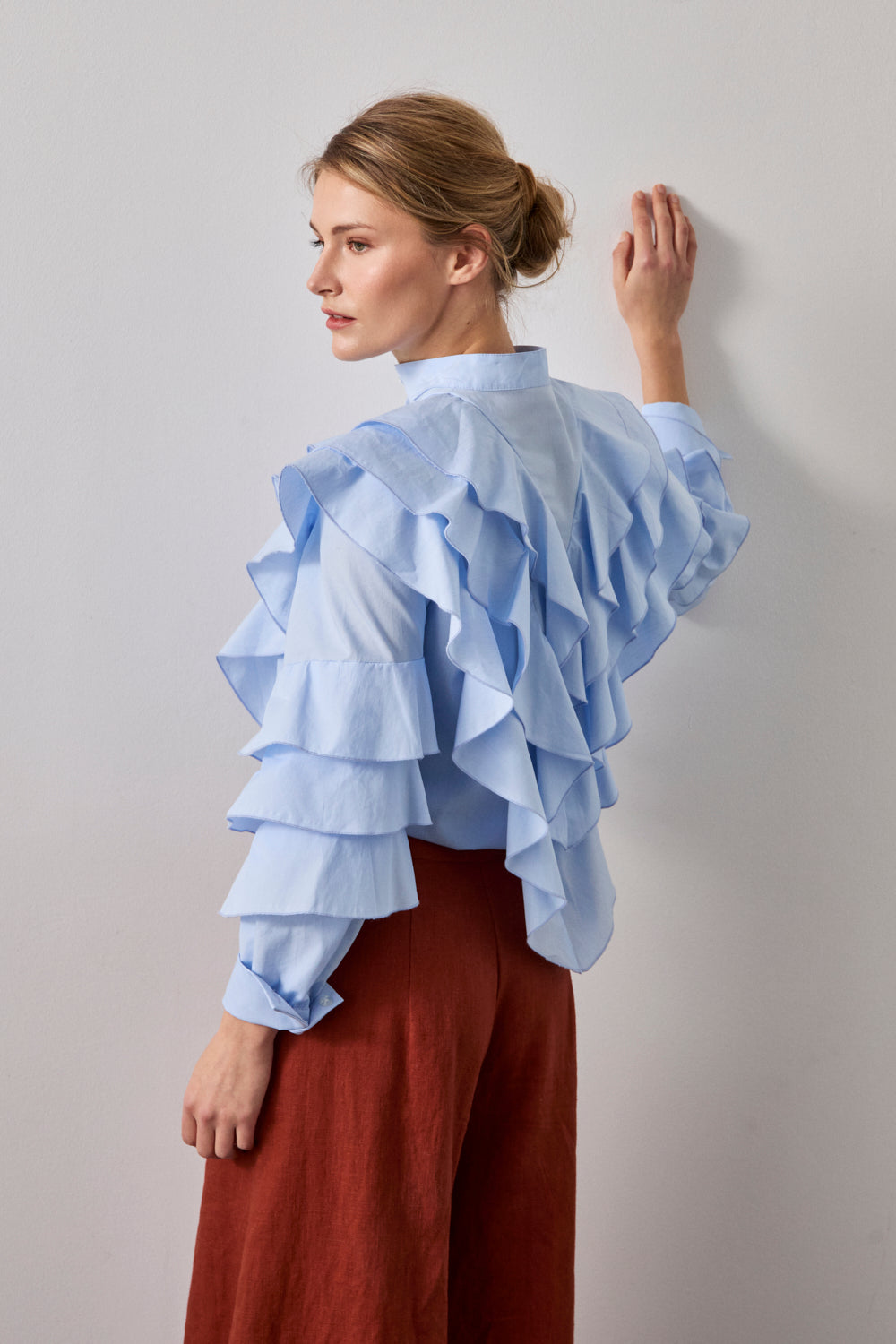 Camisa celeste de manga larga con volante en pecho y espalda. 