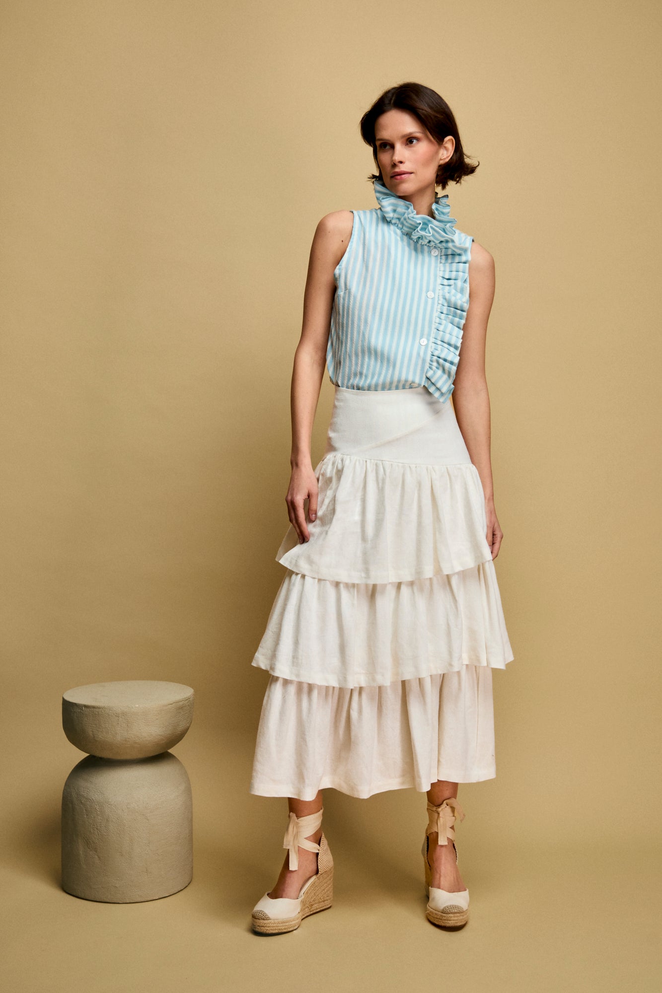 Falda midi en color blanca compuesta por volantes fruncidos.