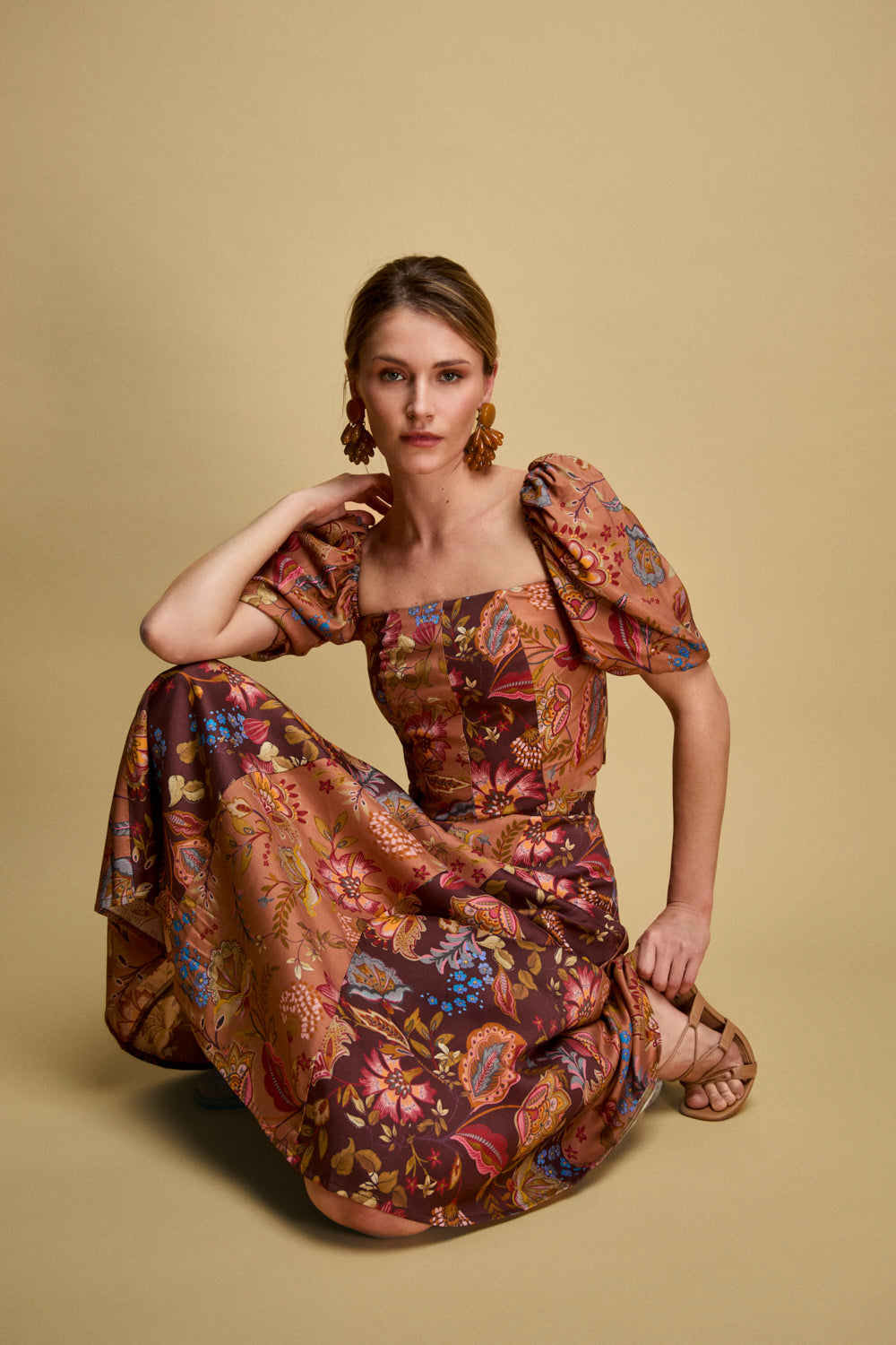 Crop top de manga corta con estampado de flores en tonos tierra. Este top tiene escote cuadrado, hombros rizados y manga engomada. 