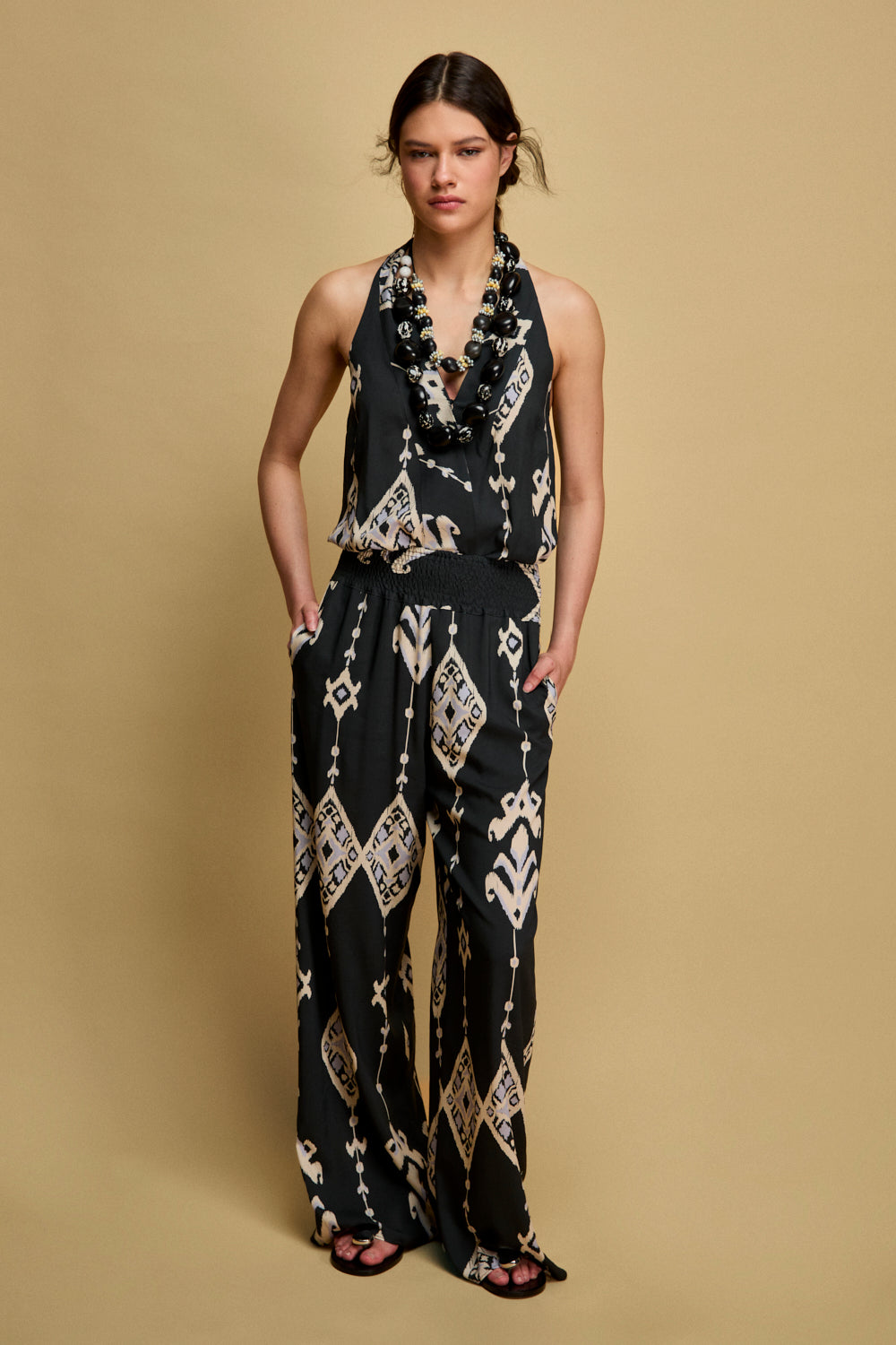 Top sin mangas en color marino con lazada en cuello. Este top tiene corchete en pecho y elástico en espalda.