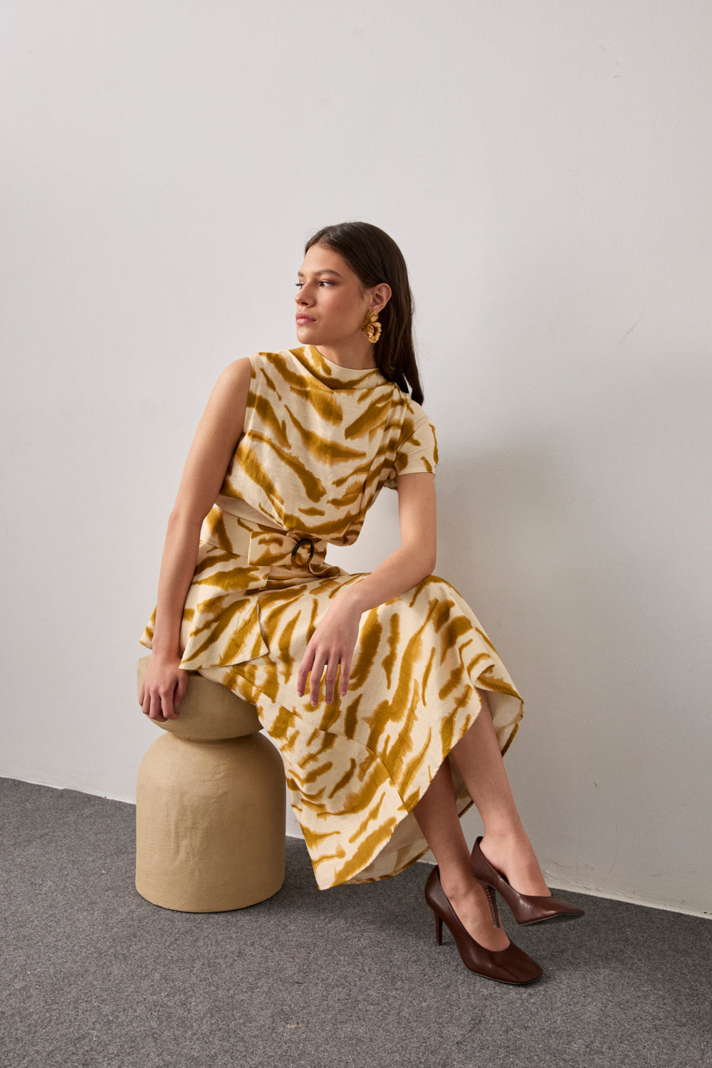 Vestido midi en color crema y manchas mostaza con mangas asimétricas.Este vestido tiene escote a la caja, corte en la cintura y cinturón confeccionado en el mismo tejido con hebilla tipo carey. 