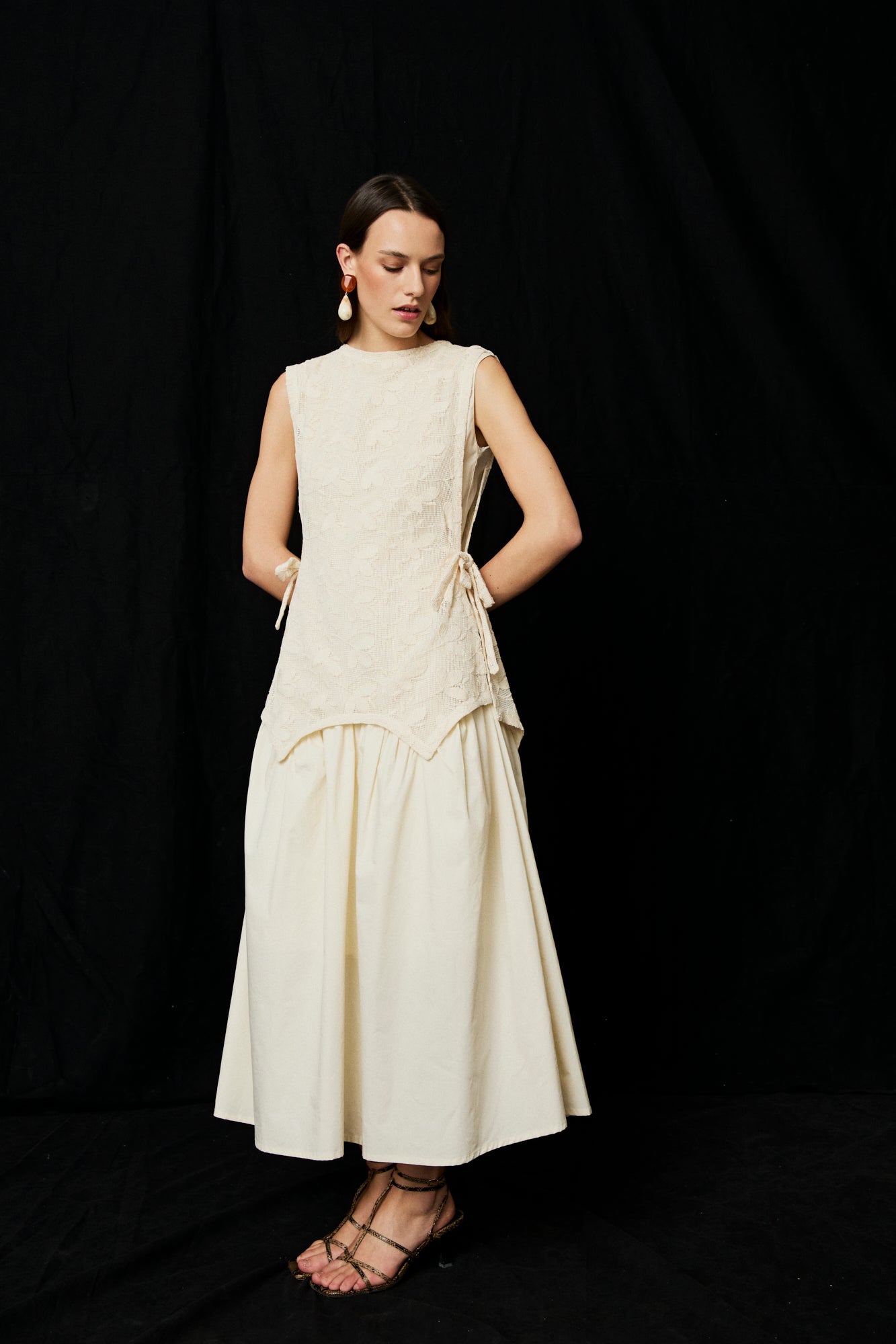 Vestido midi en color crema con top asimetrico de flores bordadas y lazadas en el lateral. 