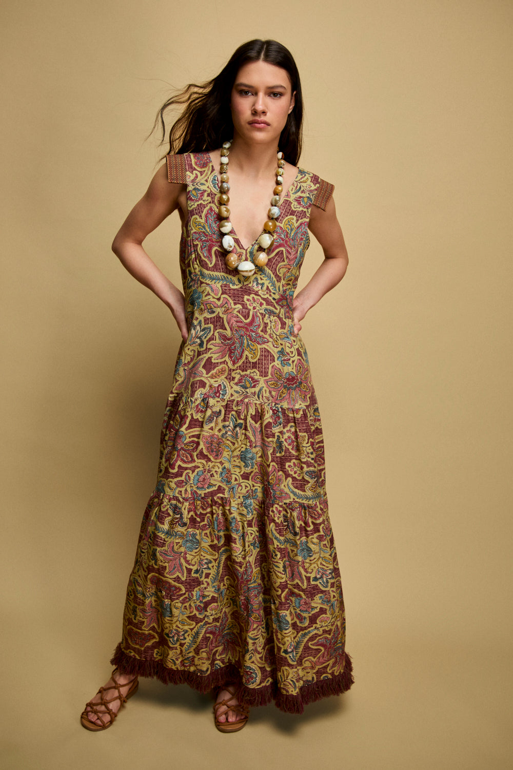 Vestido midi estampado con flores en color verde oliva y detalle de pasamanería en tirantes.Este vestido tiene escote en V y la falda cuenta con cinturilla y flecos en el bajo.